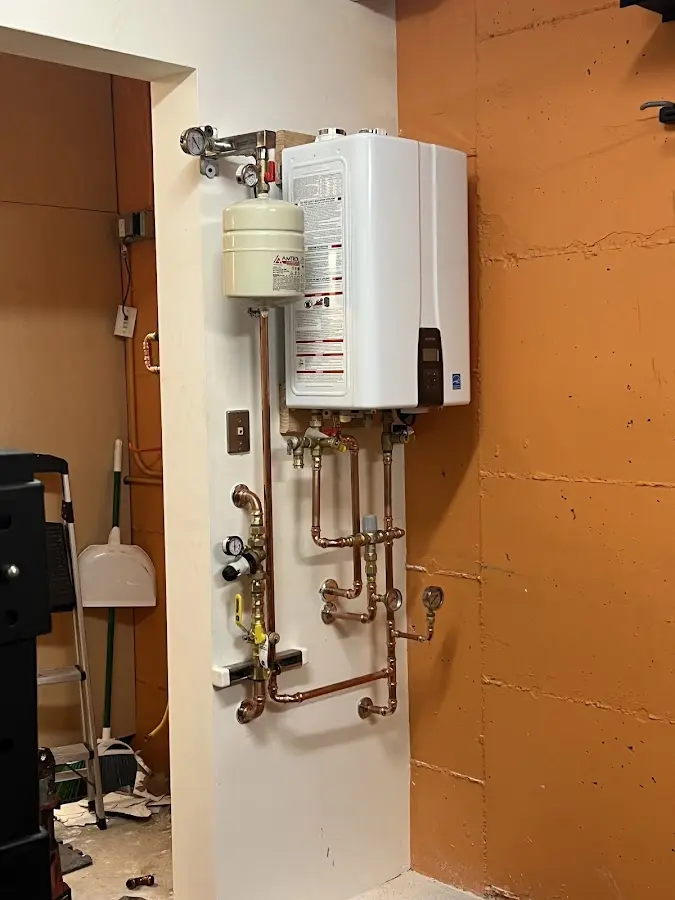 Plumbing technician inspecting water heater connections in Kinnelon